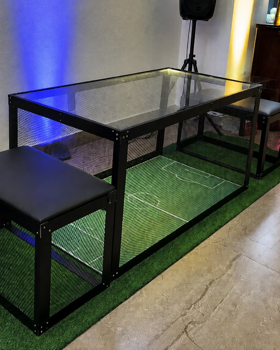 Estrutura do Banco a Banco montada, com campo de grama, laterais em acrílico e bancos nas extremidades