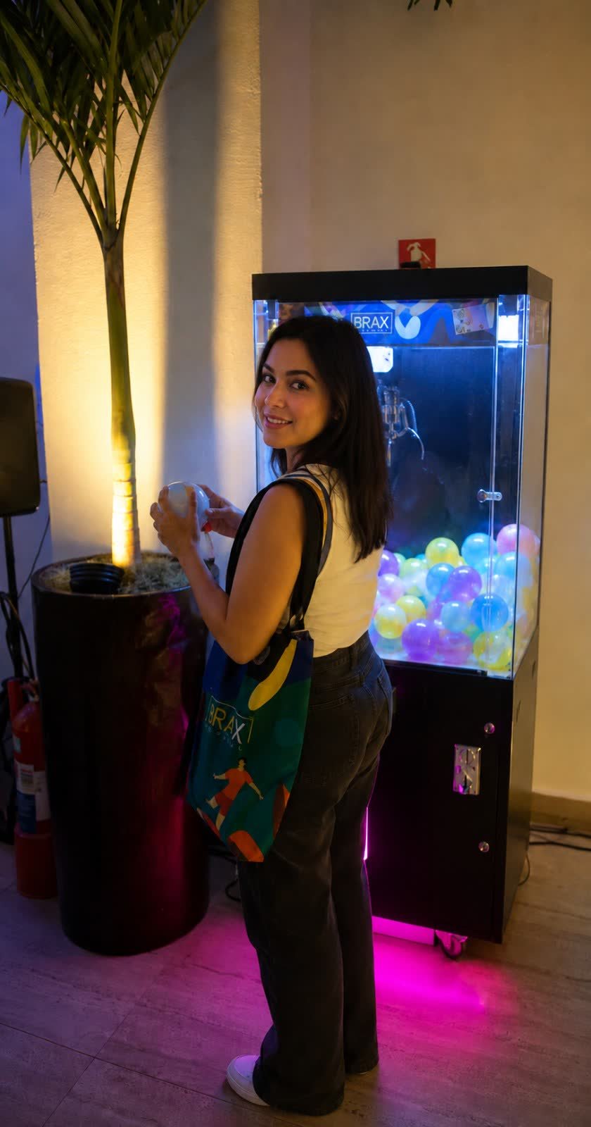 Participante com a bolinha na mão e o brinde conquistado
