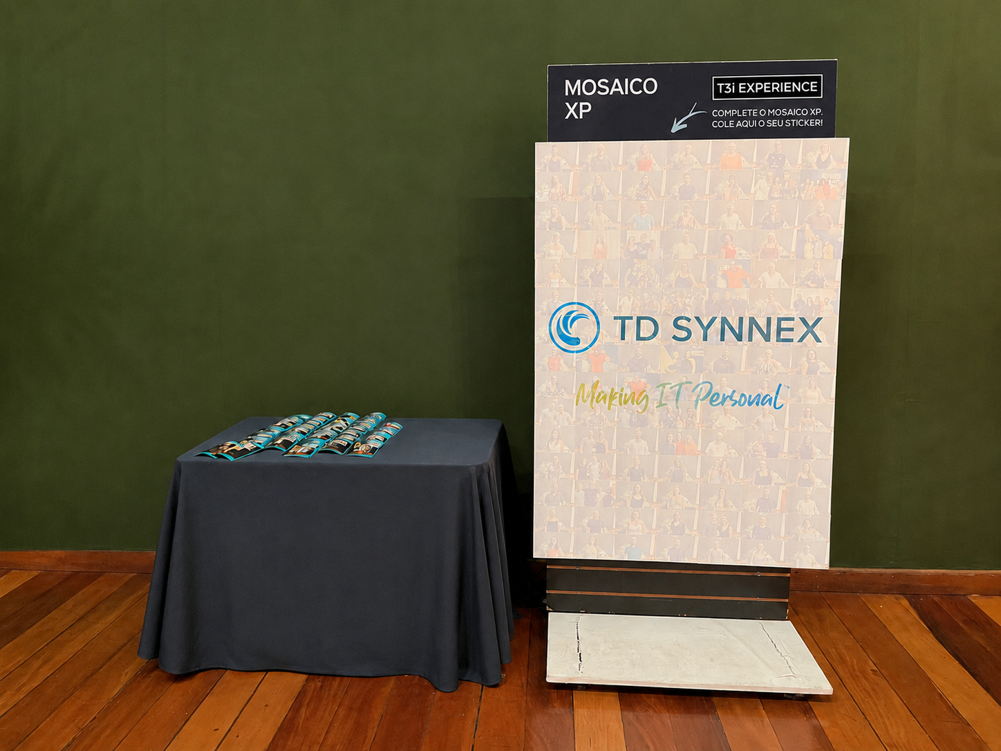 Painel do Mosaico XP montado ao lado da mesa de produção com as fotos impressas