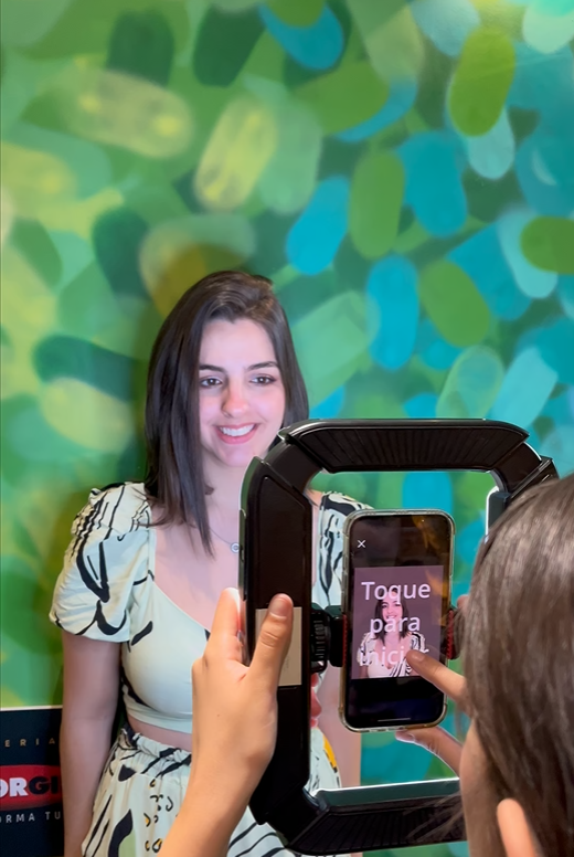 Participante posando para a foto no cenário colorido da ativação