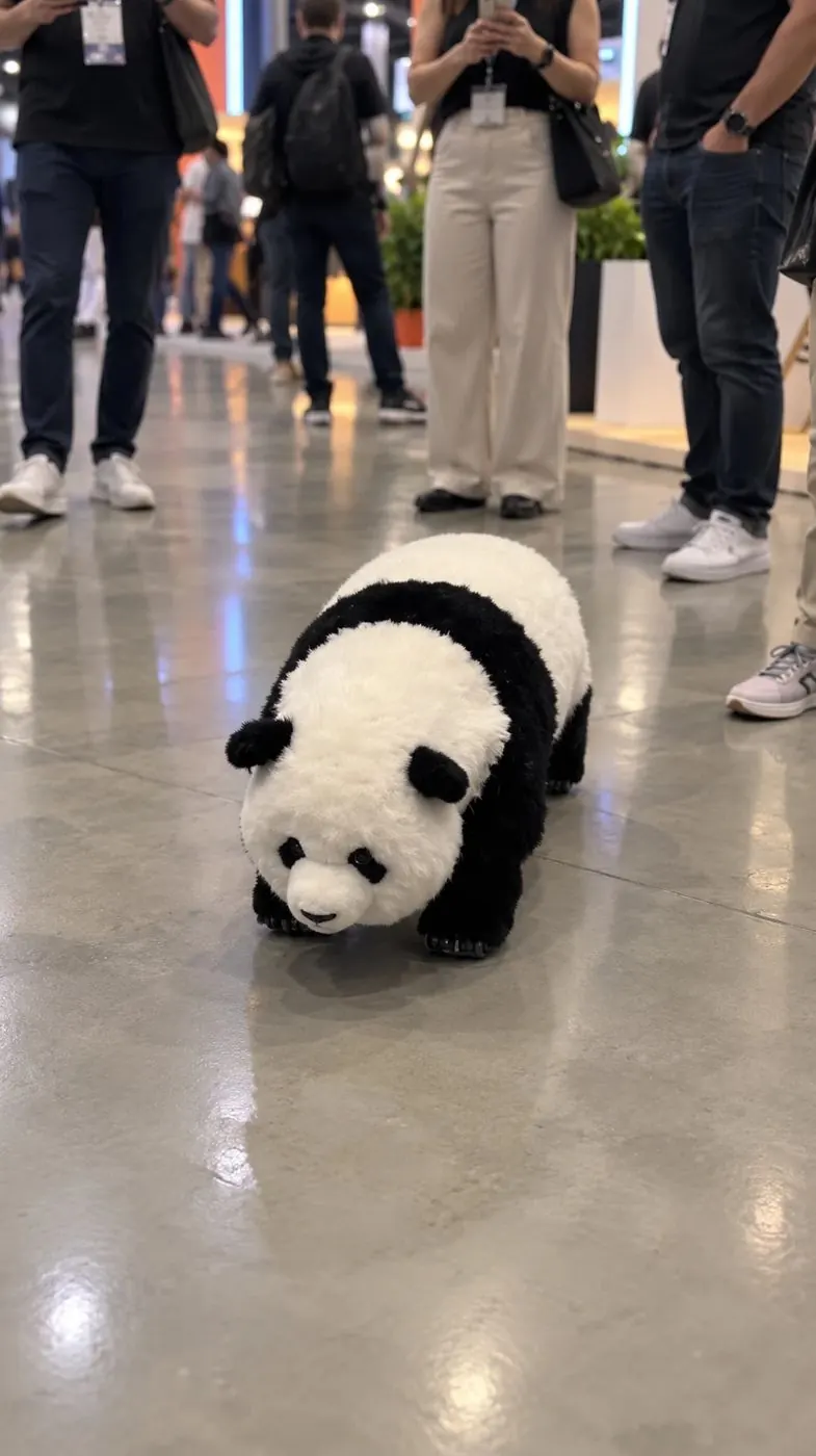Pooh Panda Robô caminhando no piso do evento, com o público em volta